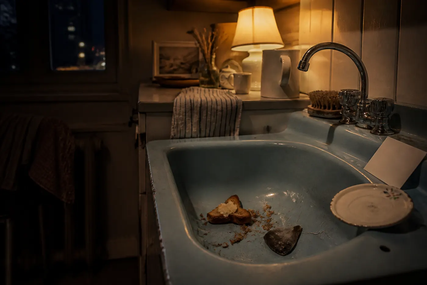 Blue enamel sink at night with buttered toast remnants