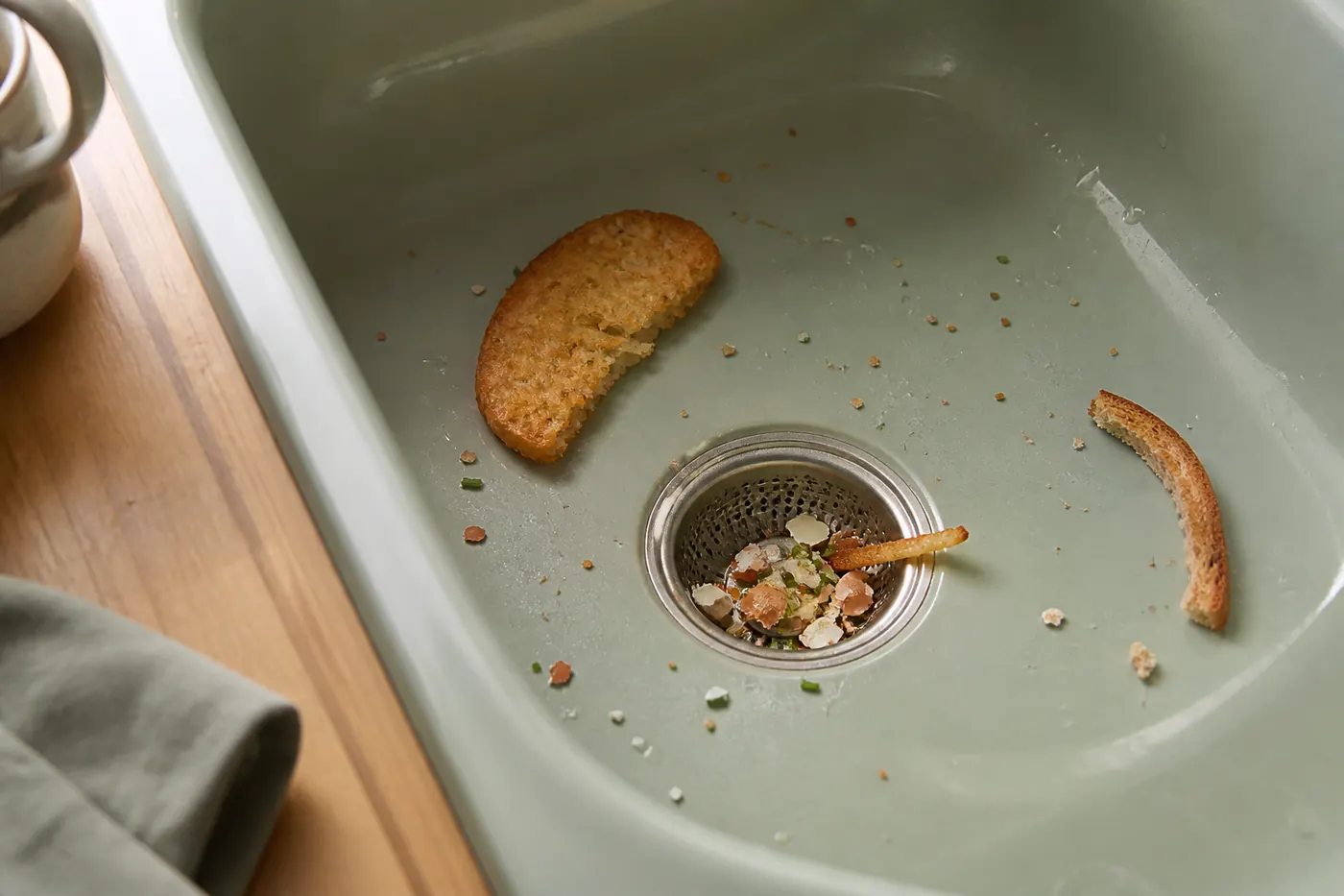 Eggshell, chive and potato in a green sink strainer with hash brown and toast crust